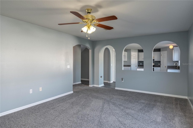 carpeted spare room featuring ceiling fan and sink