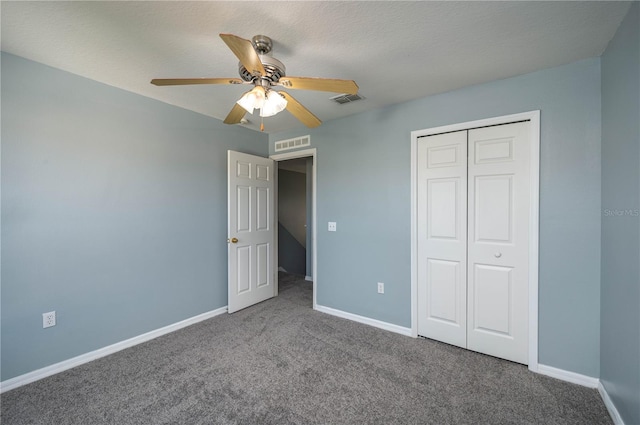 unfurnished bedroom with carpet flooring, a textured ceiling, a closet, and ceiling fan