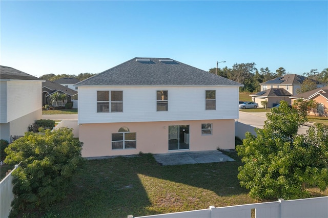 back of house with a yard and a patio