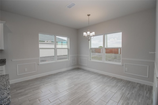 unfurnished dining area with plenty of natural light and an inviting chandelier