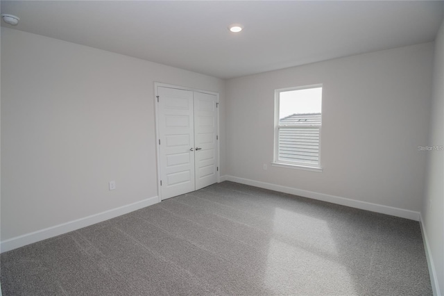 unfurnished bedroom featuring carpet flooring and a closet