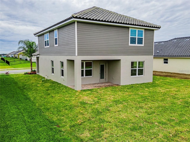 rear view of property with a lawn and a patio area