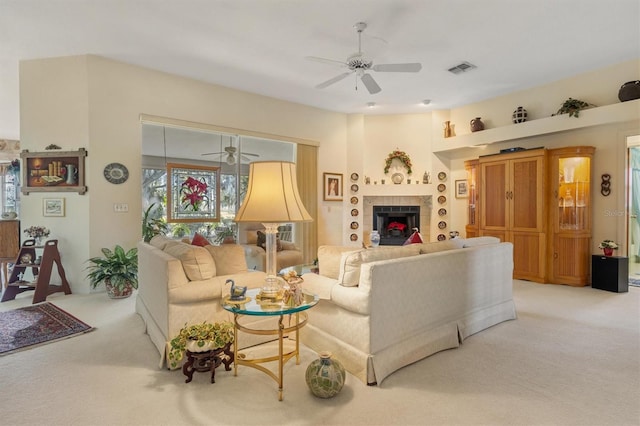 carpeted living room featuring a tiled fireplace and ceiling fan