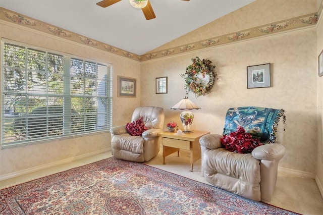 living area with carpet flooring, vaulted ceiling, and ceiling fan