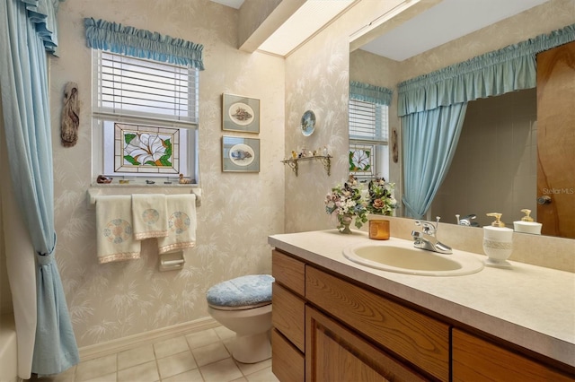 bathroom with toilet, vanity, and tile patterned floors