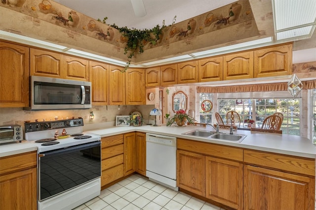 kitchen featuring light tile patterned floors, white appliances, ceiling fan, and sink