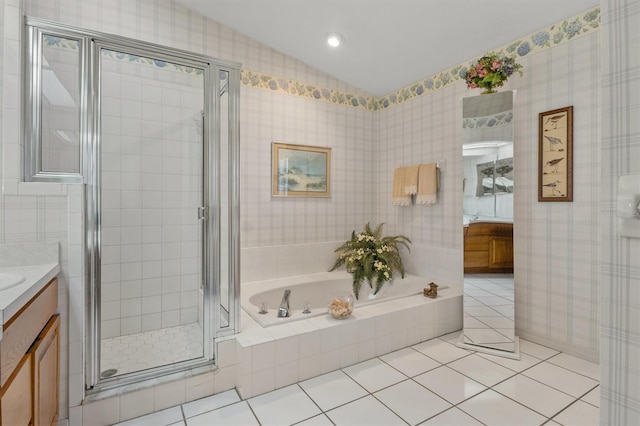 bathroom with plus walk in shower, vanity, tile patterned floors, and lofted ceiling