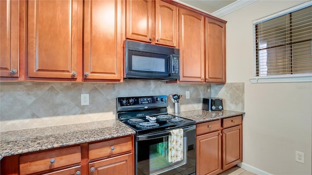 kitchen with decorative backsplash, light stone counters, and black appliances