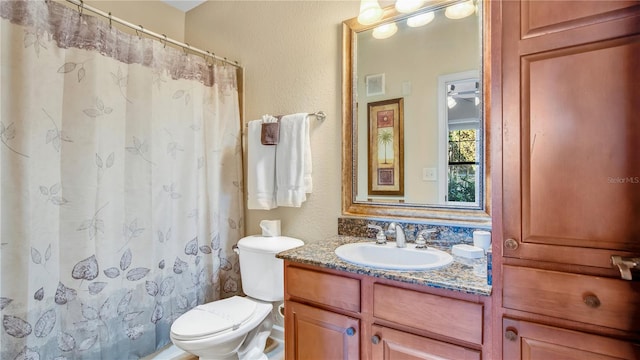 bathroom featuring walk in shower, vanity, and toilet