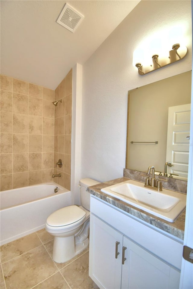 full bathroom with vanity, lofted ceiling, tile patterned floors, tiled shower / bath, and toilet