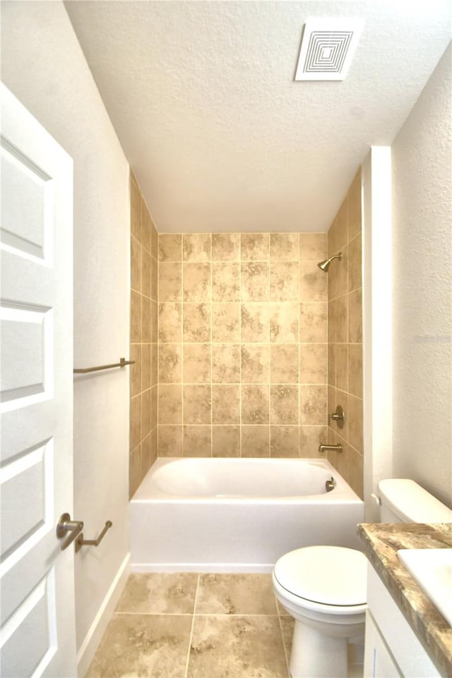 full bathroom with vanity, toilet, a textured ceiling, and tiled shower / bath combo