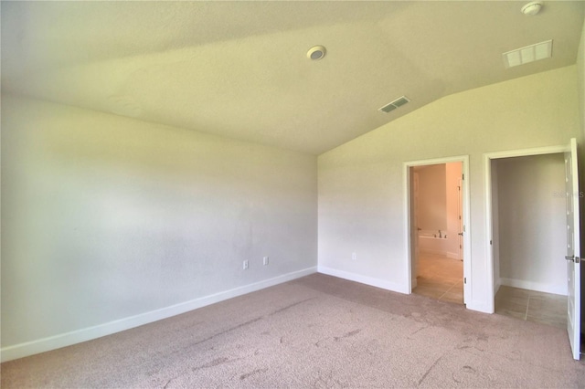 unfurnished bedroom with light carpet and lofted ceiling