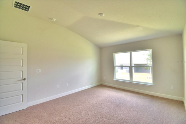 unfurnished room featuring light carpet and vaulted ceiling