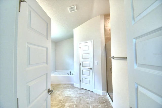 bathroom with tile patterned flooring, a textured ceiling, and independent shower and bath