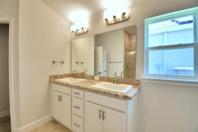 bathroom featuring a shower, vanity, tile patterned floors, and a wealth of natural light