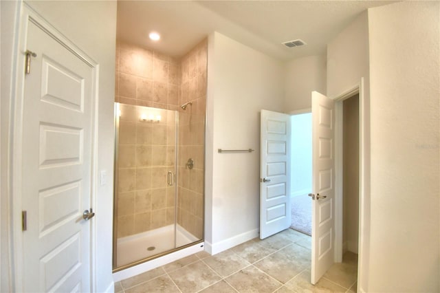 bathroom with tile patterned floors and a shower with door