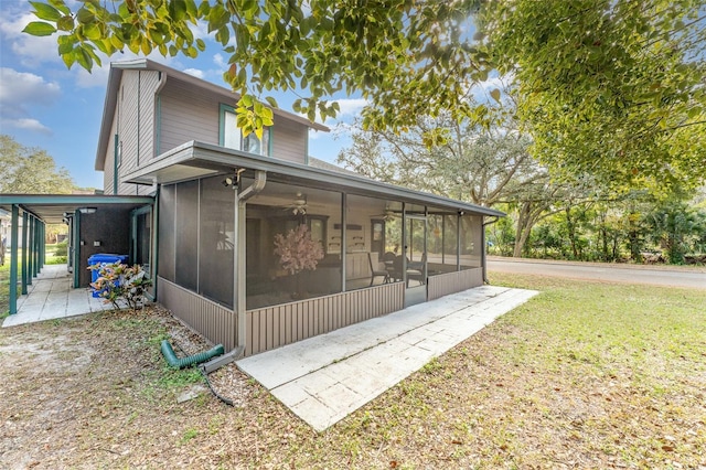 view of side of property with a sunroom and a lawn