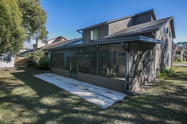 rear view of property with a sunroom and a yard