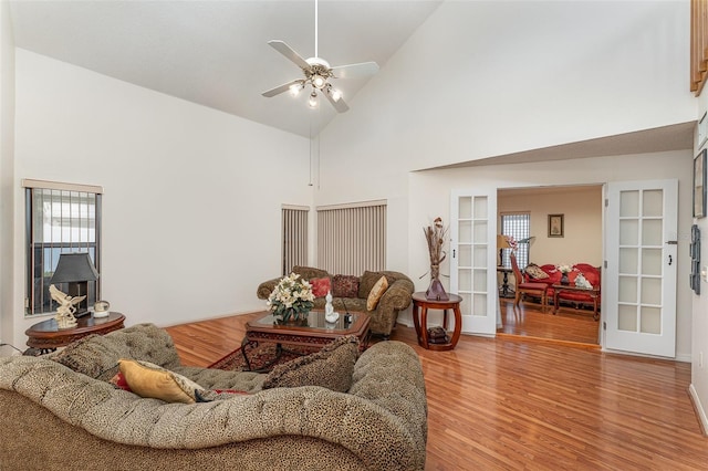 living area featuring light wood-style floors, high vaulted ceiling, a ceiling fan, and french doors