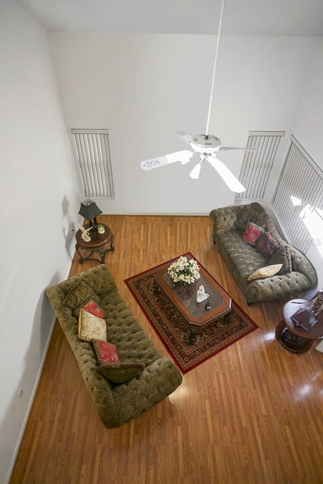 living room with ceiling fan, wood finished floors, and baseboards