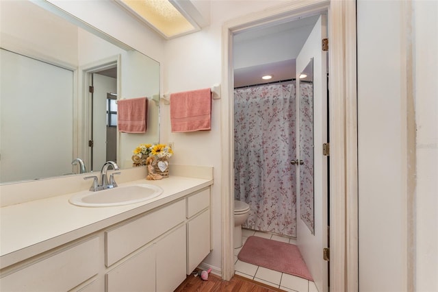 bathroom featuring toilet, a shower with curtain, tile patterned flooring, and vanity