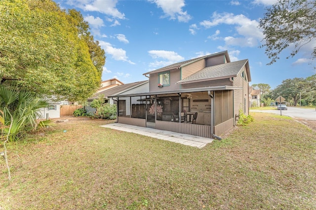 back of property featuring a sunroom and a lawn