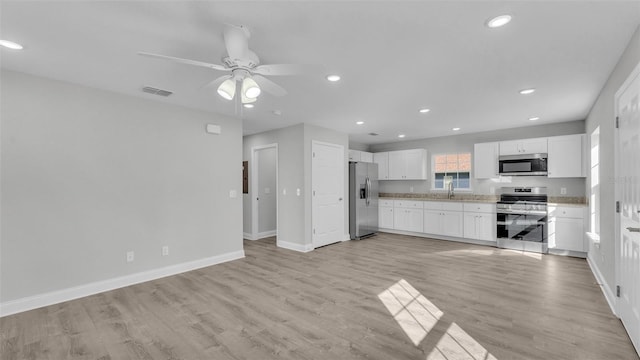 kitchen featuring white cabinetry, sink, light hardwood / wood-style flooring, and appliances with stainless steel finishes