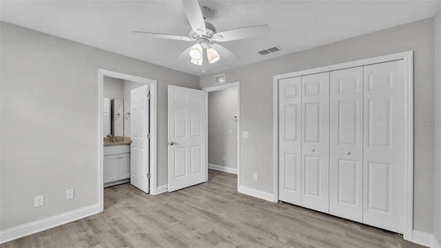 unfurnished bedroom featuring ceiling fan, ensuite bathroom, a closet, and light wood-type flooring