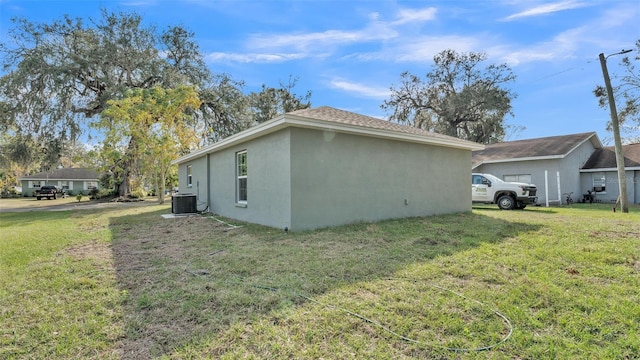 view of side of home with a lawn and central air condition unit