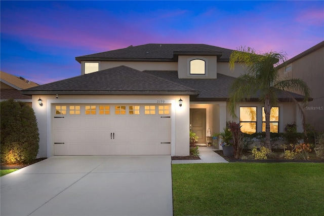 view of front of house with a garage and a yard