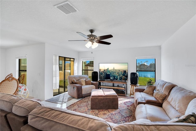 living room with ceiling fan and a textured ceiling