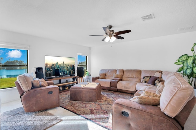 carpeted living room featuring a wealth of natural light and ceiling fan