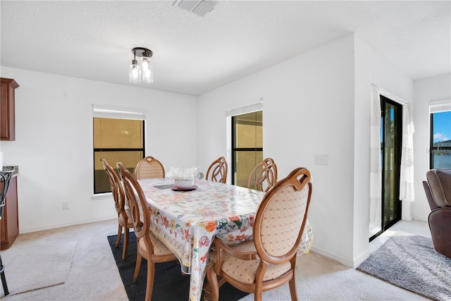 carpeted dining space featuring a textured ceiling