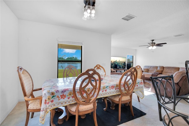 carpeted dining area featuring ceiling fan