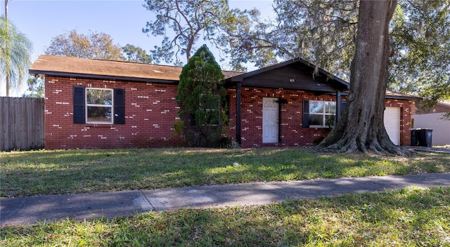 ranch-style home featuring a garage and a front lawn