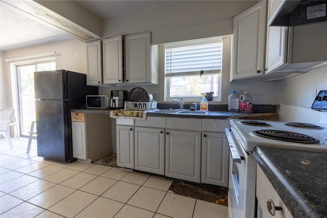 kitchen featuring black fridge, custom range hood, sink, white cabinets, and white range with electric cooktop