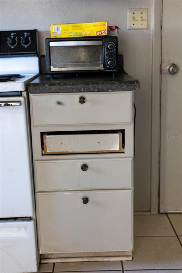 interior details featuring white cabinetry and white range with electric cooktop