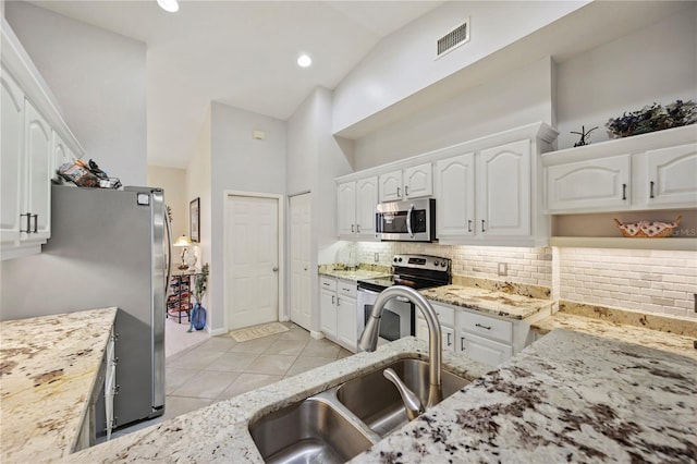 kitchen featuring white cabinets, sink, high vaulted ceiling, backsplash, and stainless steel appliances