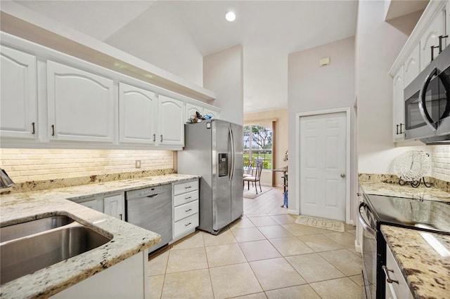 kitchen with sink, white cabinets, light tile patterned floors, and appliances with stainless steel finishes