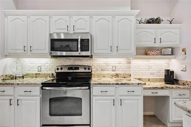 kitchen featuring white cabinets, stainless steel appliances, light stone countertops, and backsplash