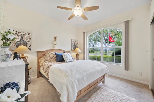 bedroom featuring ceiling fan, light carpet, and multiple windows