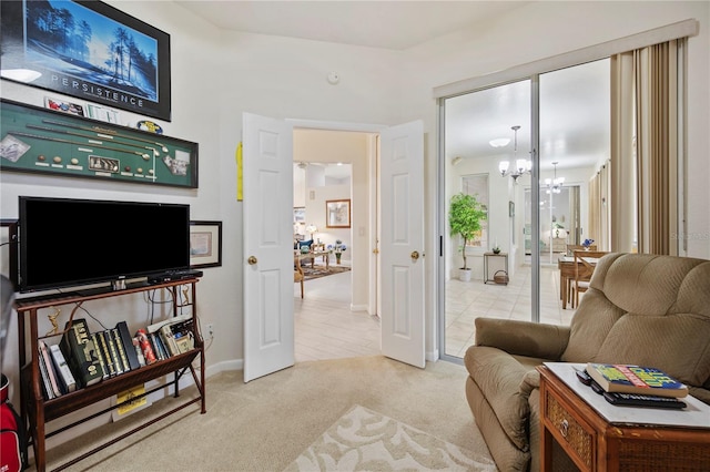 sitting room featuring light carpet and an inviting chandelier