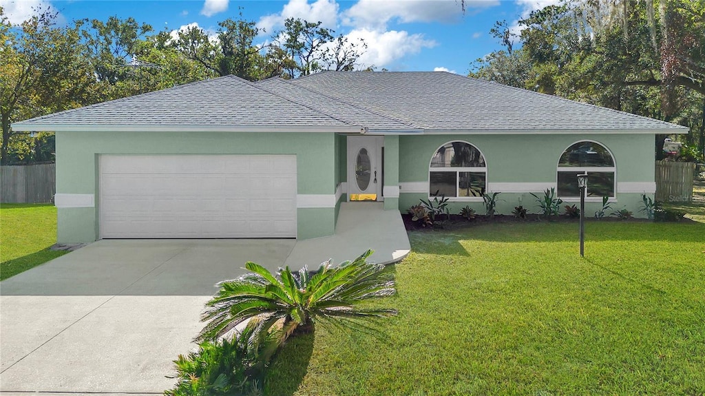 ranch-style house featuring a garage and a front yard