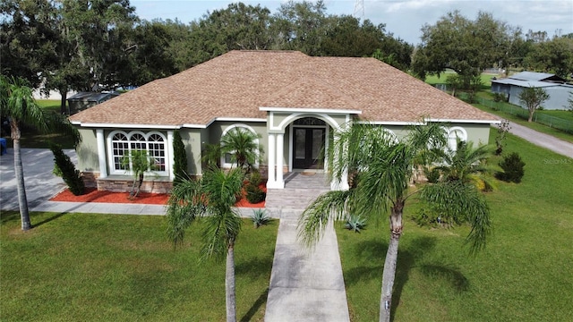 view of front of house with a front lawn and french doors