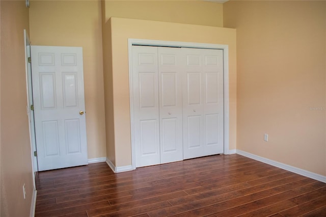 unfurnished bedroom with a closet and dark hardwood / wood-style floors