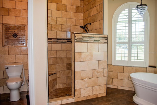 bathroom with hardwood / wood-style floors, an inviting chandelier, separate shower and tub, and tile walls