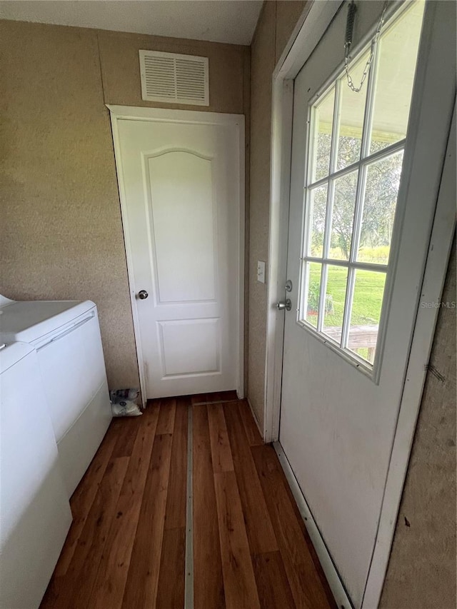 interior space with plenty of natural light, dark hardwood / wood-style floors, and independent washer and dryer