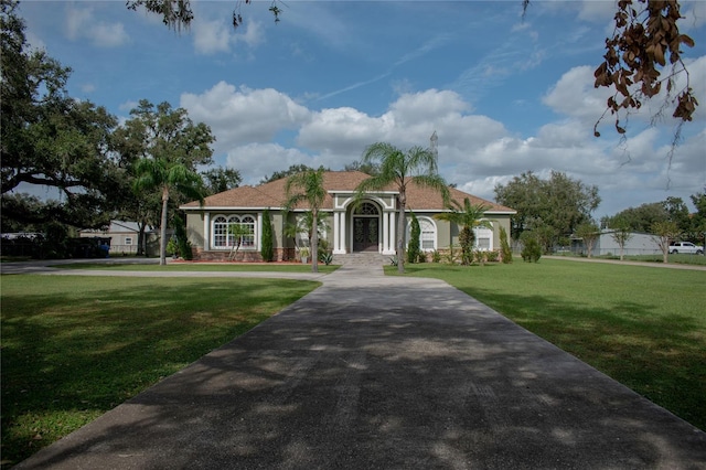 2638 E Knights Griffin Rd, Plant City, FL 33565 - mediterranean / spanish-style house with a front yard and stucco siding