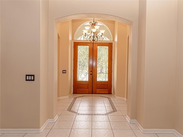 2638 E Knights Griffin Rd, Plant City, FL 33565 - entrance foyer with a chandelier, baseboards, french doors, inlaid floor details, and arched walkways