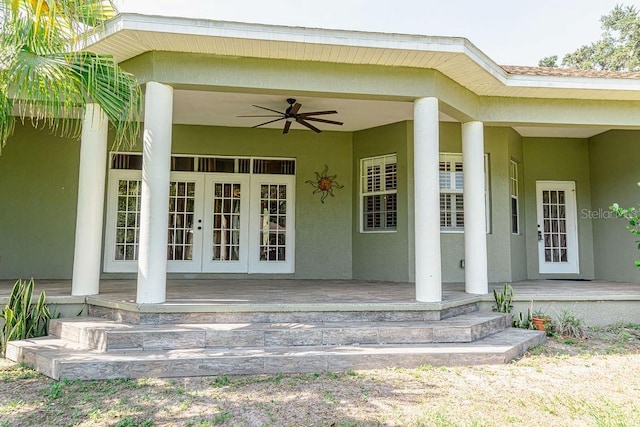 2638 E Knights Griffin Rd, Plant City, FL 33565 - property entrance featuring french doors, stucco siding, a ceiling fan, and a porch